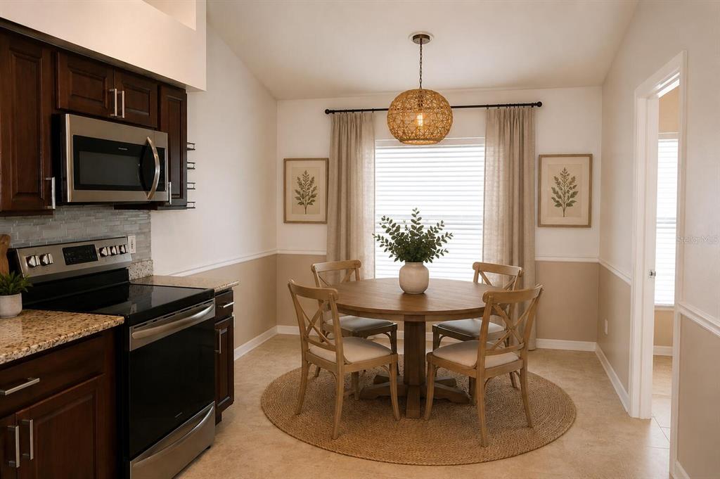 A kitchen dining area features a round wooden table, four chairs, and a pendant light — 14648 CORKWOOD DRIVE, TAMPA, FL
