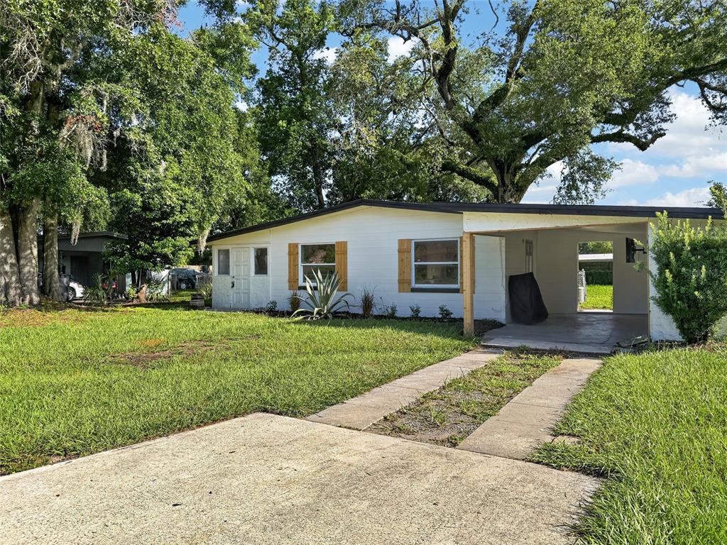 A single-story white house with a carport, wooden shutters, and a concrete driveway — 3911 LAKE MARGARET DRIVE, ORLANDO, FL