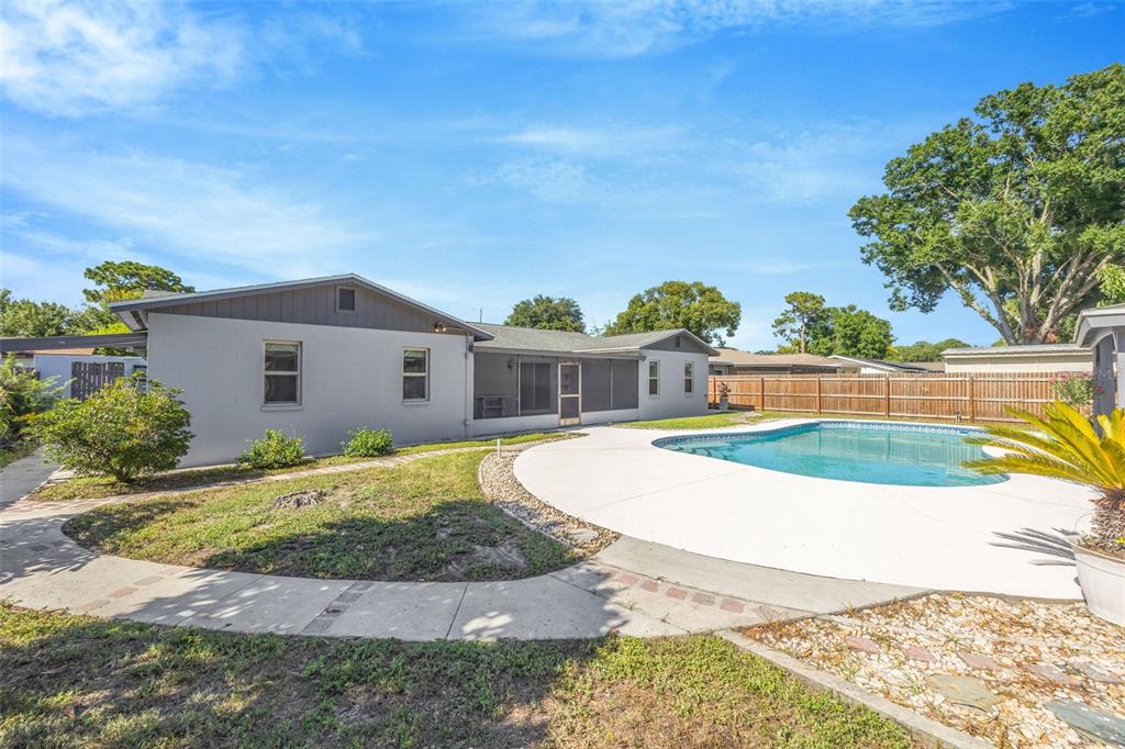 A gray house with a screened-in porch and a swimming pool in the backyard — 4608 SOUTHBREEZE DRIVE, TAMPA, FL