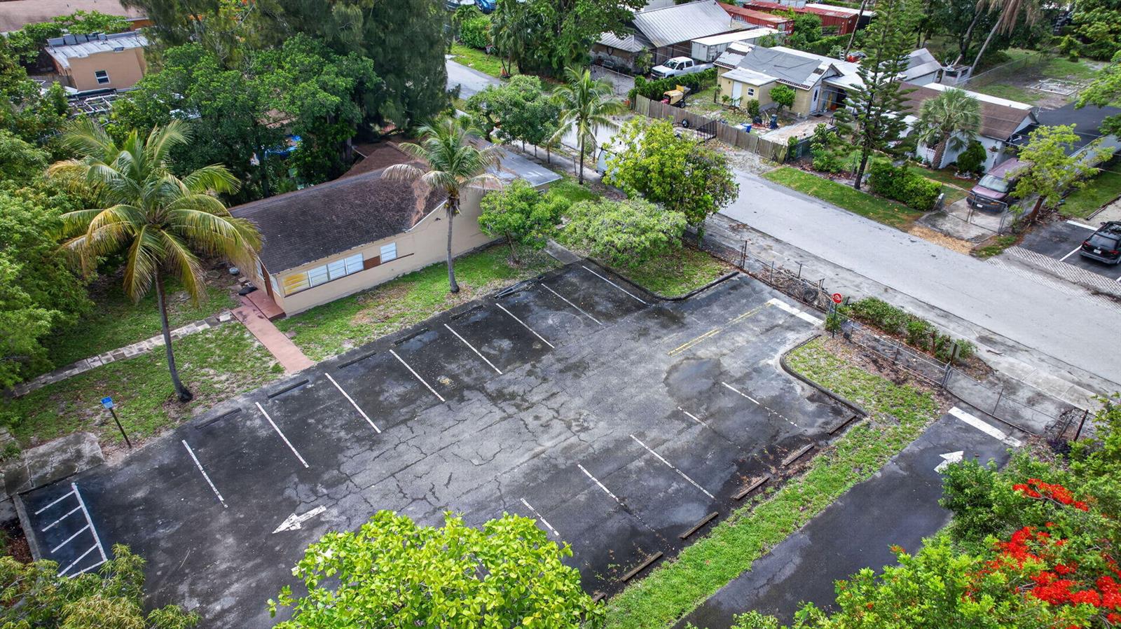 An aerial view shows a paved parking lot next to a small residential house — 129 NW 11th Street, Pompano Beach FL 33060, POMPANO BEACH, FL