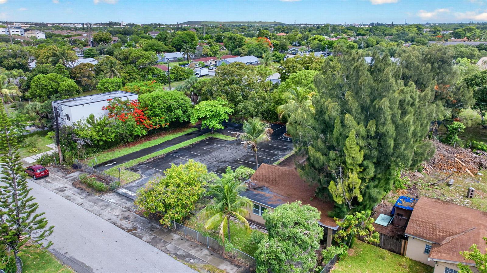 An aerial view shows a small parking lot next to a house with a brown roof — 129 NW 11th Street, Pompano Beach FL 33060, POMPANO BEACH, FL