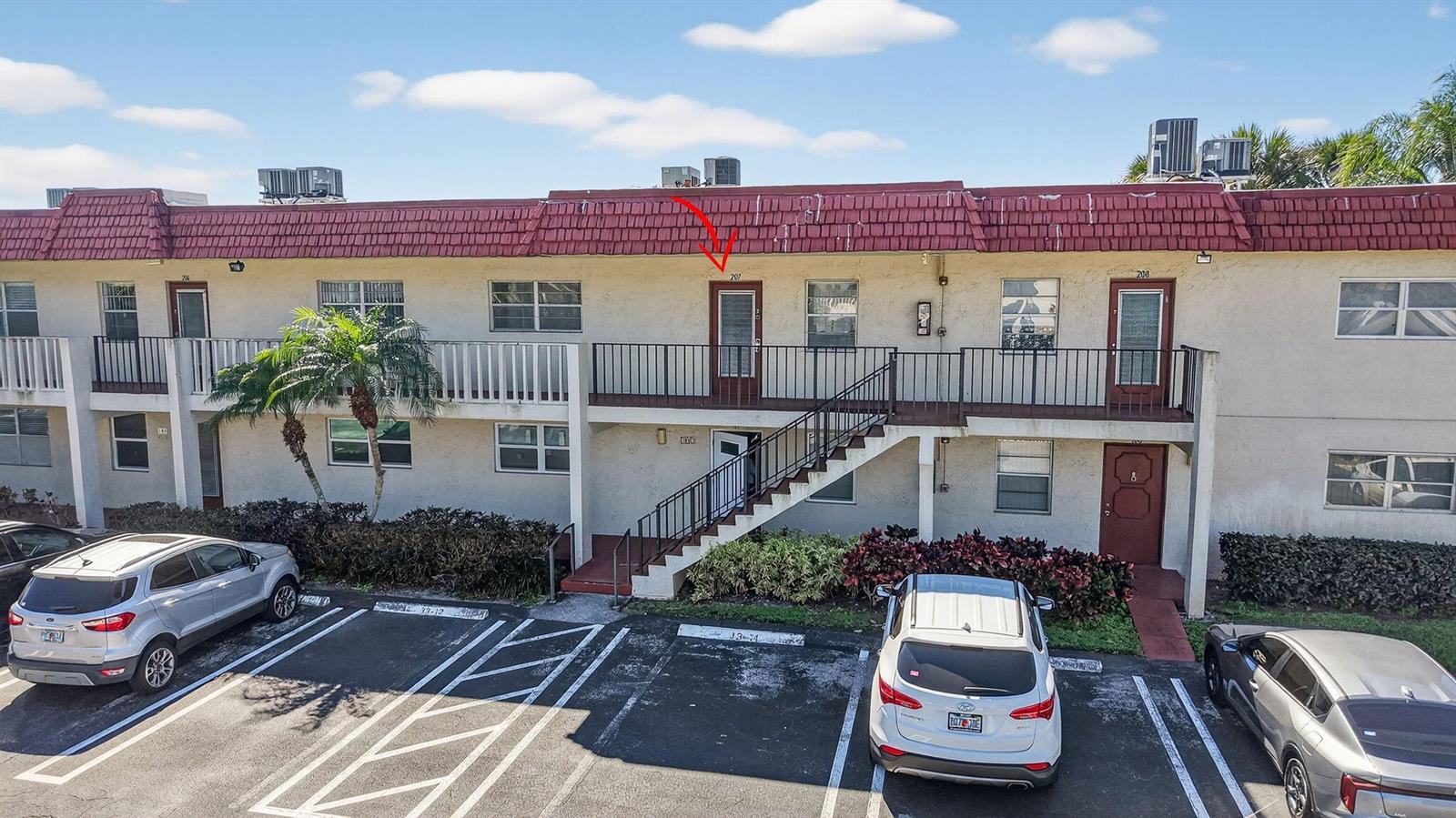 An exterior view of a two-story apartment building with a red tile roof — 33 Abbey Lane # 207, Delray Beach FL 33446, DELRAY BEACH, FL