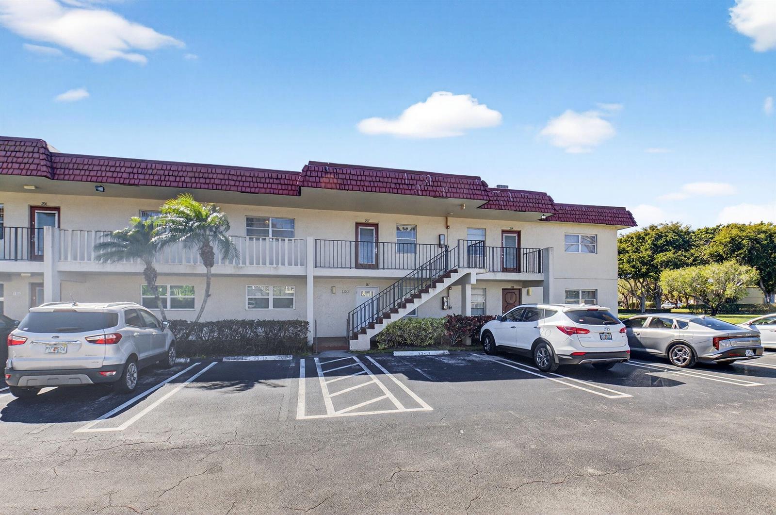 A two-story apartment building with a red tile roof and a parking lot in front — 33 Abbey Lane # 207, Delray Beach FL 33446, DELRAY BEACH, FL