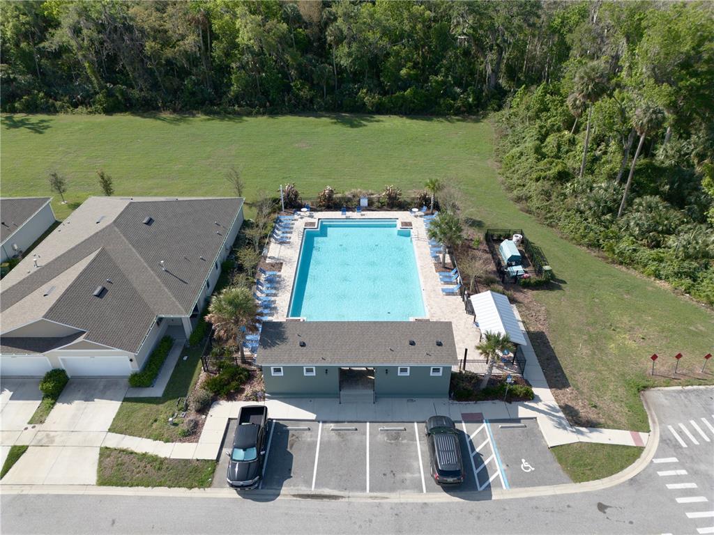 An aerial view shows a community swimming pool, a clubhouse, and a parking lot — 29320 ARMOYAN BOULEVARD, LEESBURG, FL