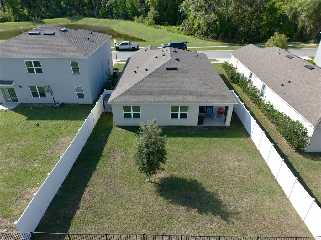 An aerial view shows the backyard and rear exterior of a single-story suburban house — 29320 ARMOYAN BOULEVARD, LEESBURG, FL
