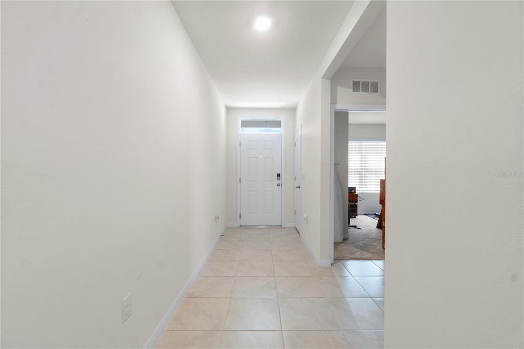A bright entryway features light-colored floor tiles, white walls, and a white front door — 29320 ARMOYAN BOULEVARD, LEESBURG, FL