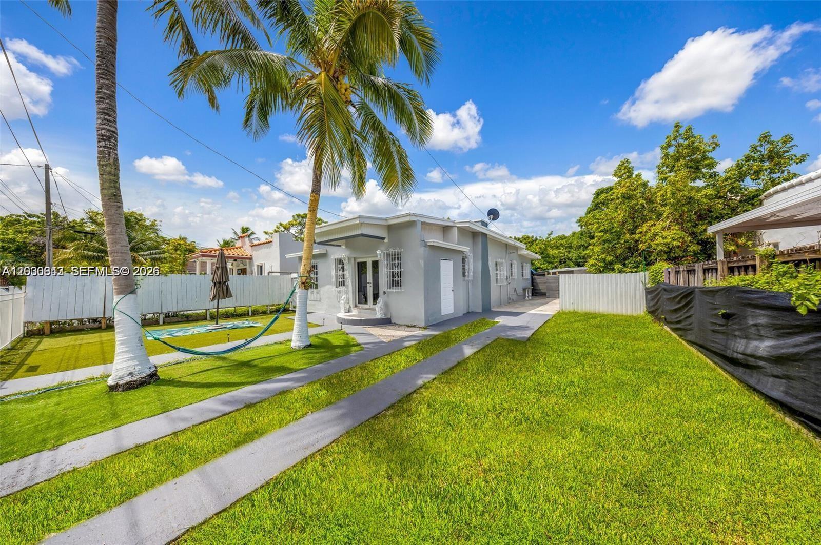 A gray one-story house features a palm tree, a hammock, and a grassy yard — 3128 NW 3rd Ave, Miami FL 33127, MIAMI, FL