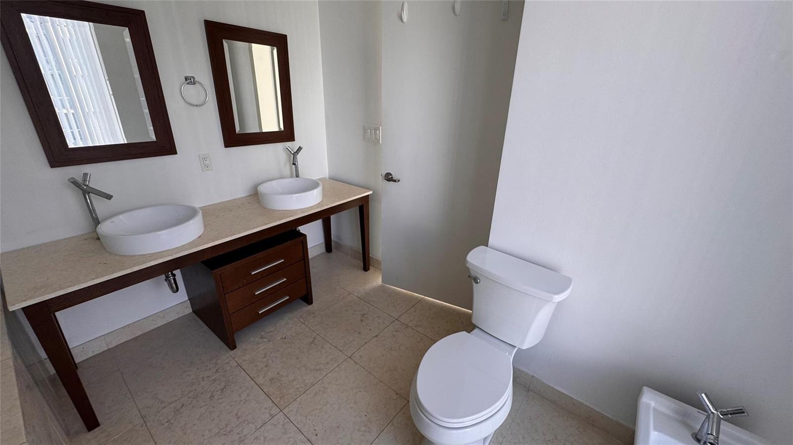 A bathroom features a double vanity with vessel sinks, a toilet, and tile flooring — 475 Brickell Avenue # 4913, Miami FL 33131, MIAMI, FL