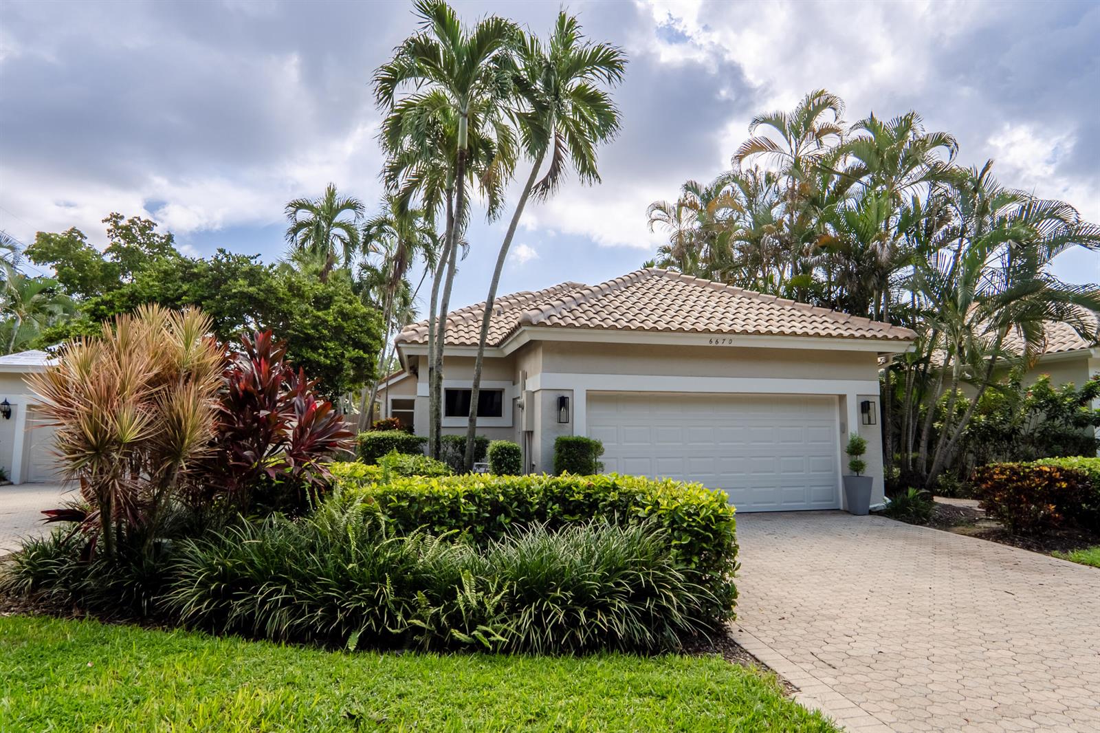 A single-story house with a tiled roof, a two-car garage, and lush tropical landscaping — 6670 NW 27th Avenue, Boca Raton FL 33496, BOCA RATON, FL