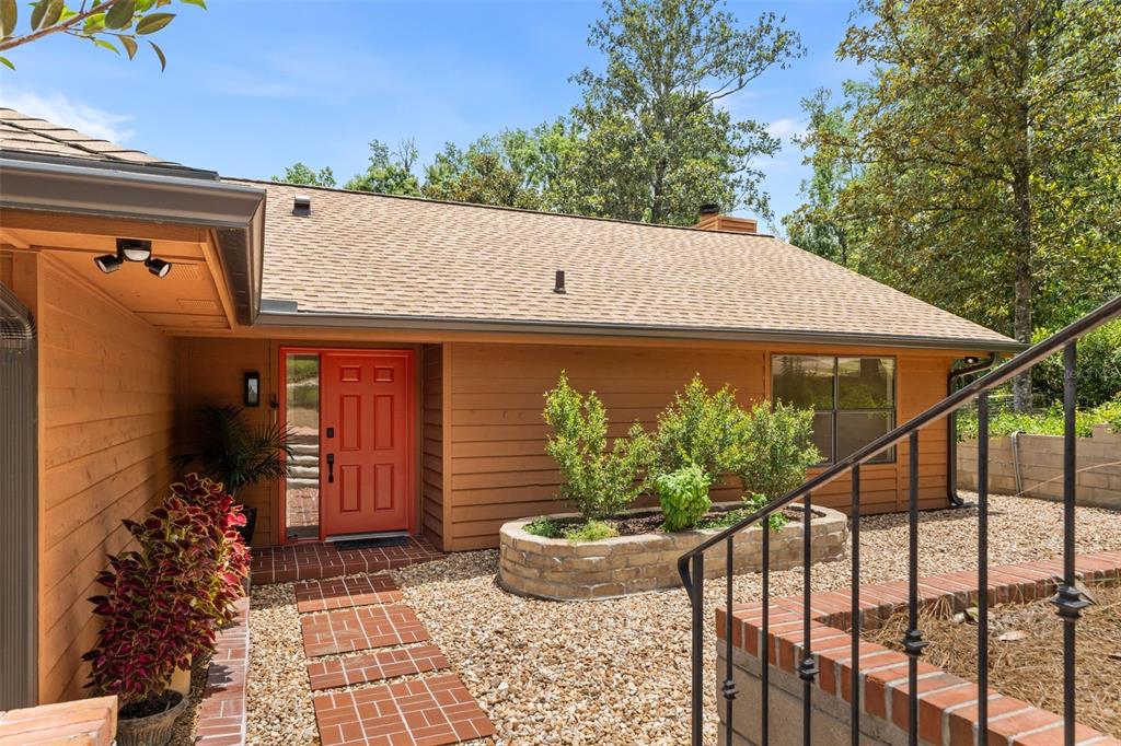 A house exterior features a red front door, tan wood siding, and a brick walkway — 11715 NW 122ND TERRACE, ALACHUA, FL