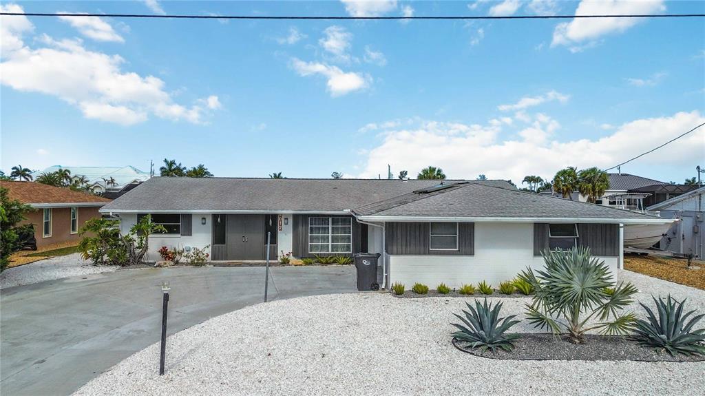 A single-story house with a white exterior, gray roof, and a gravel front yard — 4012 99TH STREET W, BRADENTON, FL