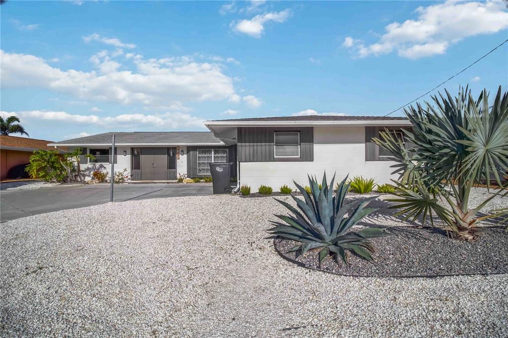 A single-story house with a gravel front yard, desert landscaping, and a gray-painted exterior — 4012 99TH STREET W, BRADENTON, FL