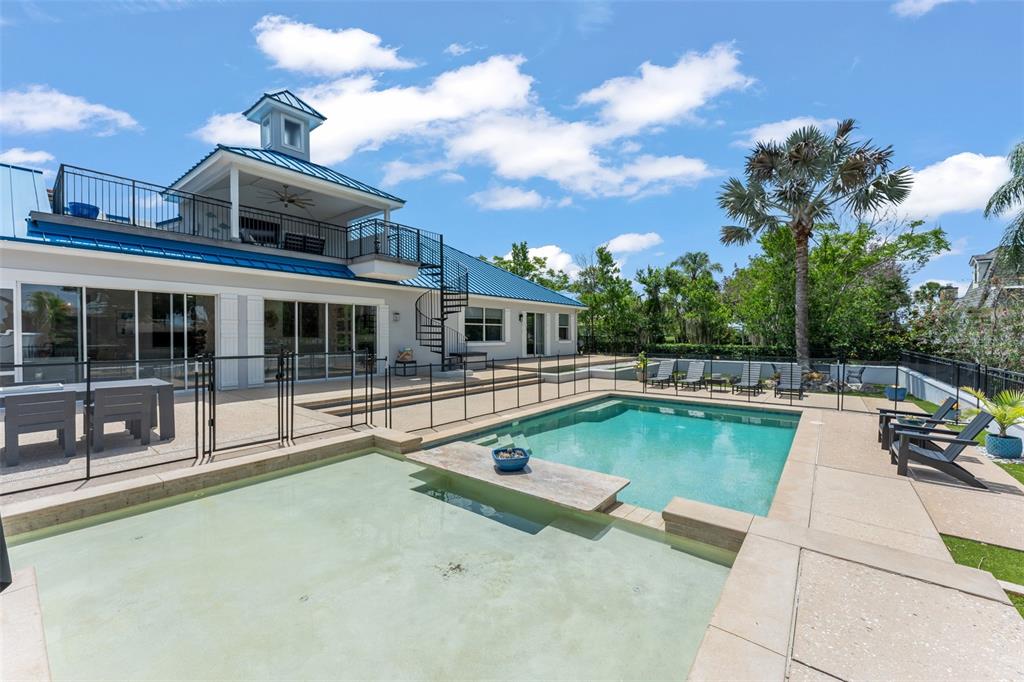 A backyard features a swimming pool, a shallow tanning ledge, and a two-story house — 9958 KILGORE ROAD, ORLANDO, FL