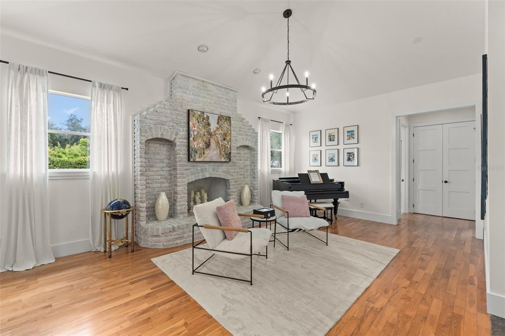 A living room features a white brick fireplace, a grand piano, and hardwood floors — 9958 KILGORE ROAD, ORLANDO, FL