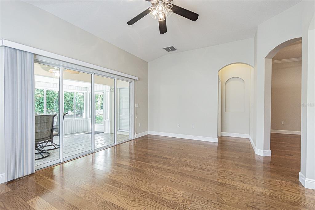 A dining room with hardwood floors, a wooden table, and sliding glass doors to a patio — 10312 OLD TAMPA BAY DRIVE, SAN ANTONIO, FL
