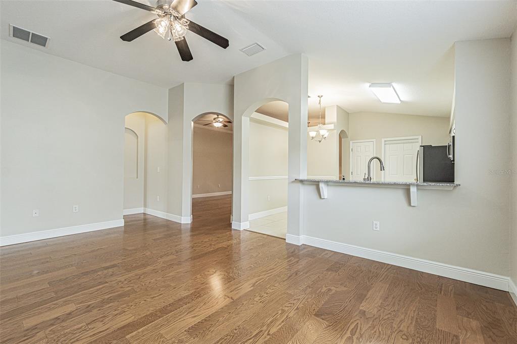 A living and dining area features hardwood floors, a neutral color palette, and modern furniture — 10312 OLD TAMPA BAY DRIVE, SAN ANTONIO, FL
