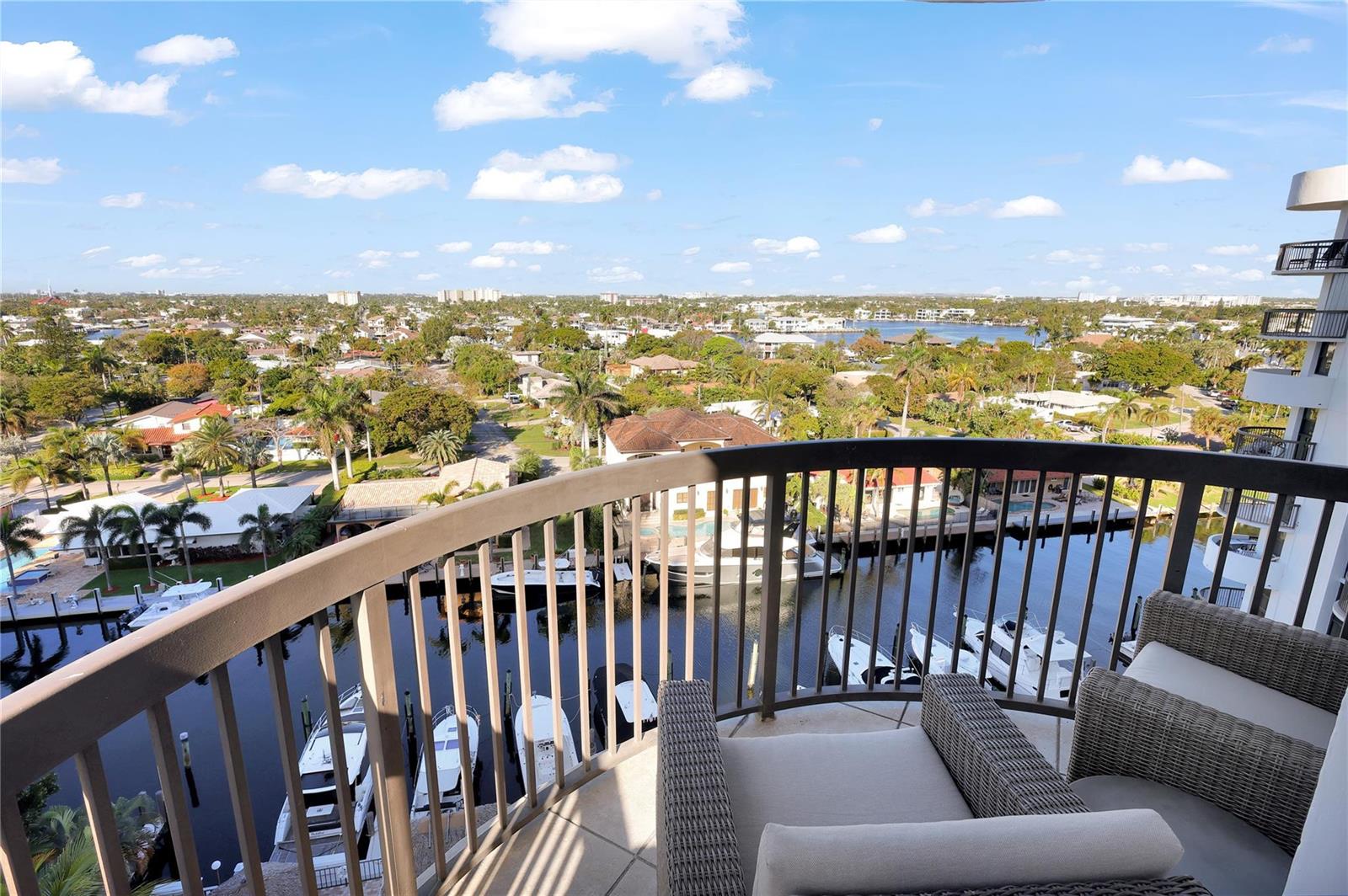 A high-angle view from a balcony overlooking a canal with boats and residential homes — 1361 S Ocean Boulevard # 910, Pompano Beach FL 33062, POMPANO BEACH, FL