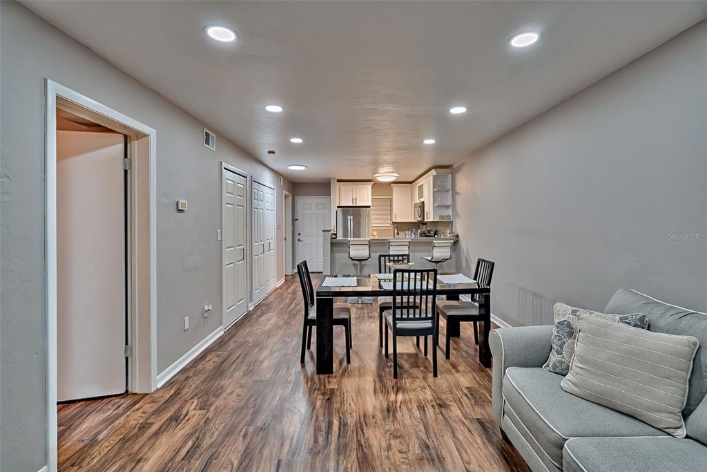 A dining area with a glass table and chairs sits in front of a kitchen — 105 SE 16TH AVENUE UNIT N103, GAINESVILLE, FL