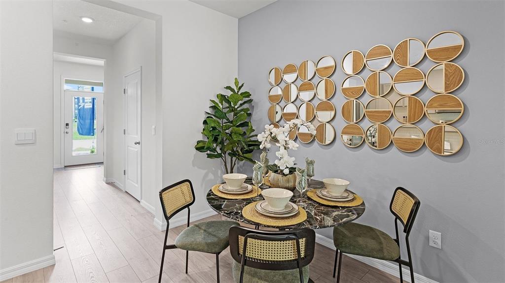 A dining area features a round marble table, cane-back chairs, and a large circular wall mirror — 3516 CHROMA STREET, ORLANDO, FL