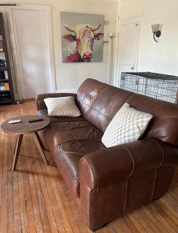 A living room features a brown leather sofa, a small round table, and cow wall art — 2601 W CLEVELAND STREET, TAMPA, FL