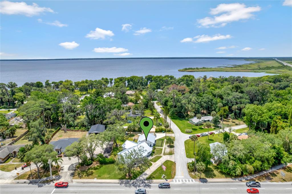 An aerial view shows a house with a green location pin near a large lake — 335 DEBARY AVENUE, DEBARY, FL