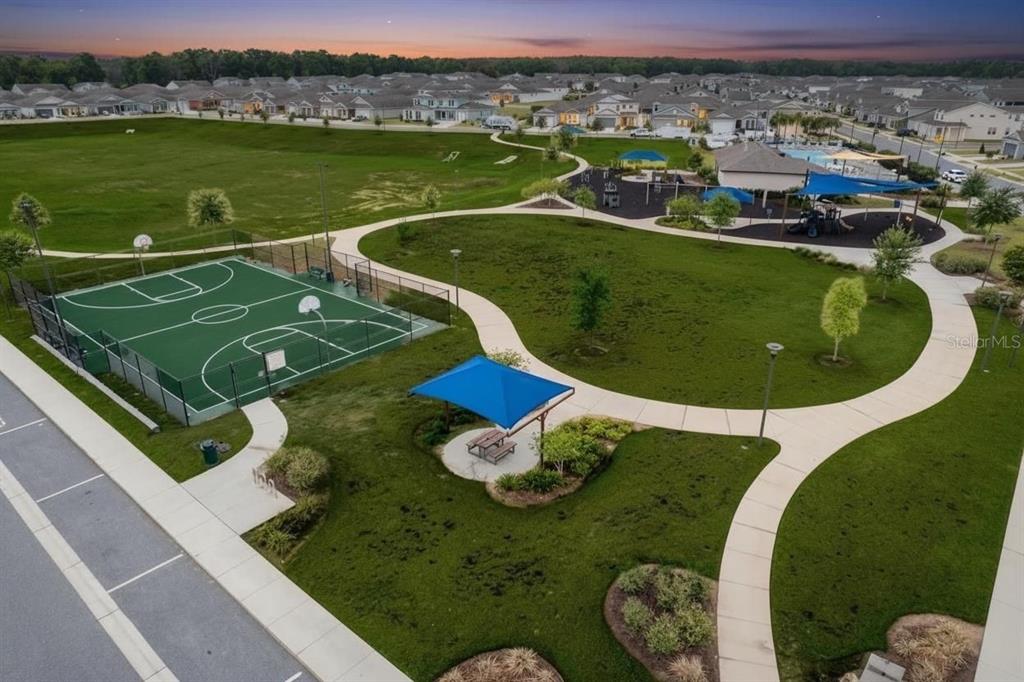 An aerial view of a community park featuring a basketball court, playground, and walking paths — 6200 SW 72ND TERRACE, OCALA, FL