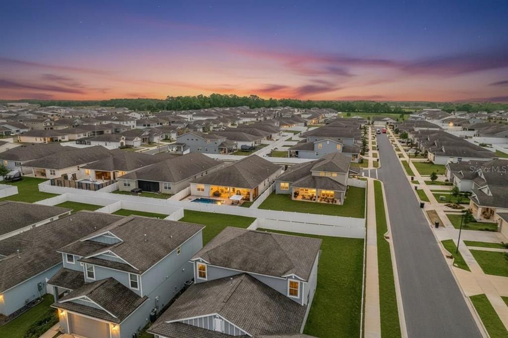 An aerial view shows a suburban neighborhood of single-family homes with white vinyl privacy fences — 6200 SW 72ND TERRACE, OCALA, FL