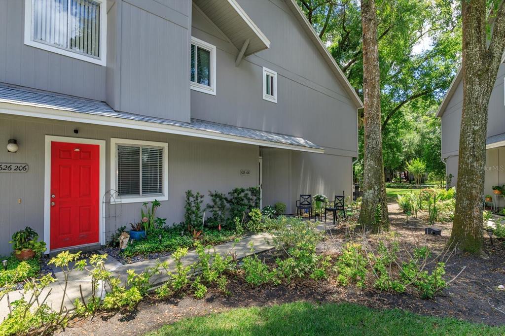 A gray two-story townhouse exterior features a bright red front door and landscaped front yard — 626 RED OAK CIRCLE UNIT 106, ALTAMONTE SPRINGS, FL