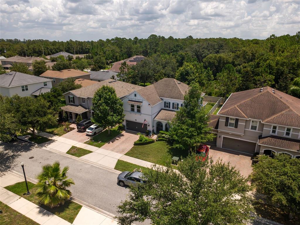 An aerial view shows several suburban houses with driveways and trees under a cloudy sky — 2317 AVELLINO AVENUE, ST CLOUD, FL
