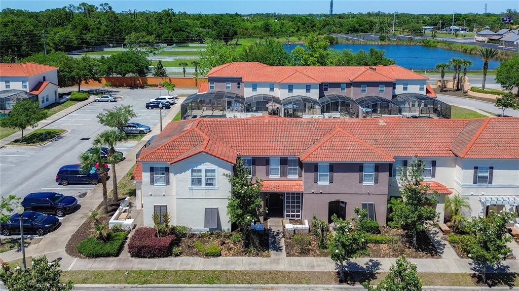 An aerial view shows a multi-unit townhouse complex with red tile roofs and parking — 4559 CORSA LANE, KISSIMMEE, FL