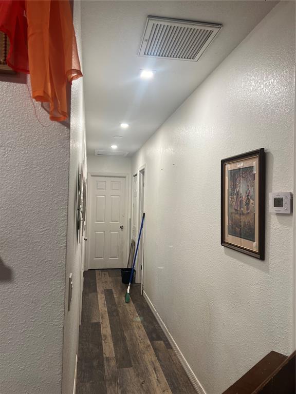 A hallway with wood-look flooring, white walls, recessed lighting, and a framed picture — 3945 47TH STREET, VERO BEACH, FL