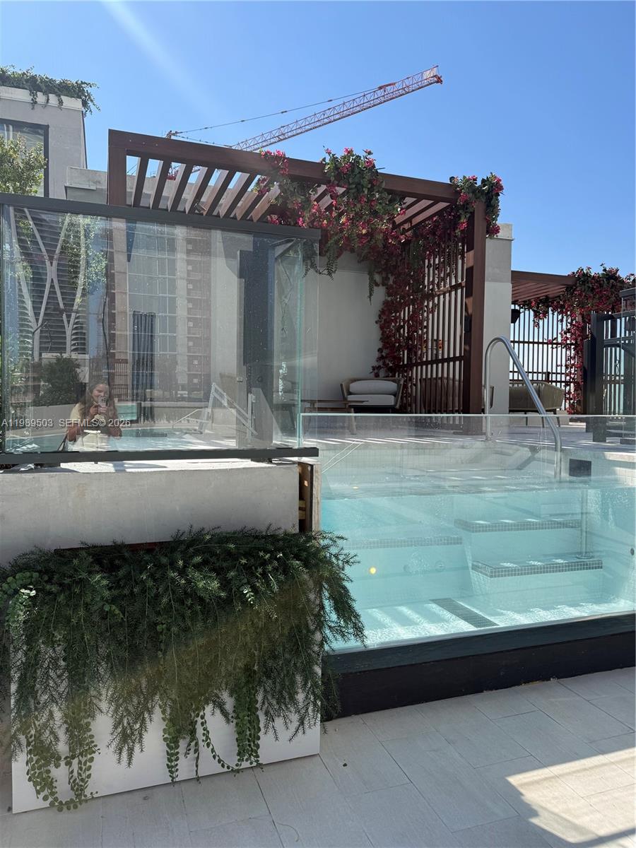 A rooftop terrace features a glass-walled plunge pool, wooden pergola, and lush climbing bougainvillea — 20 NE 11th ST # 3212b, Miami FL 33132, MIAMI, FL