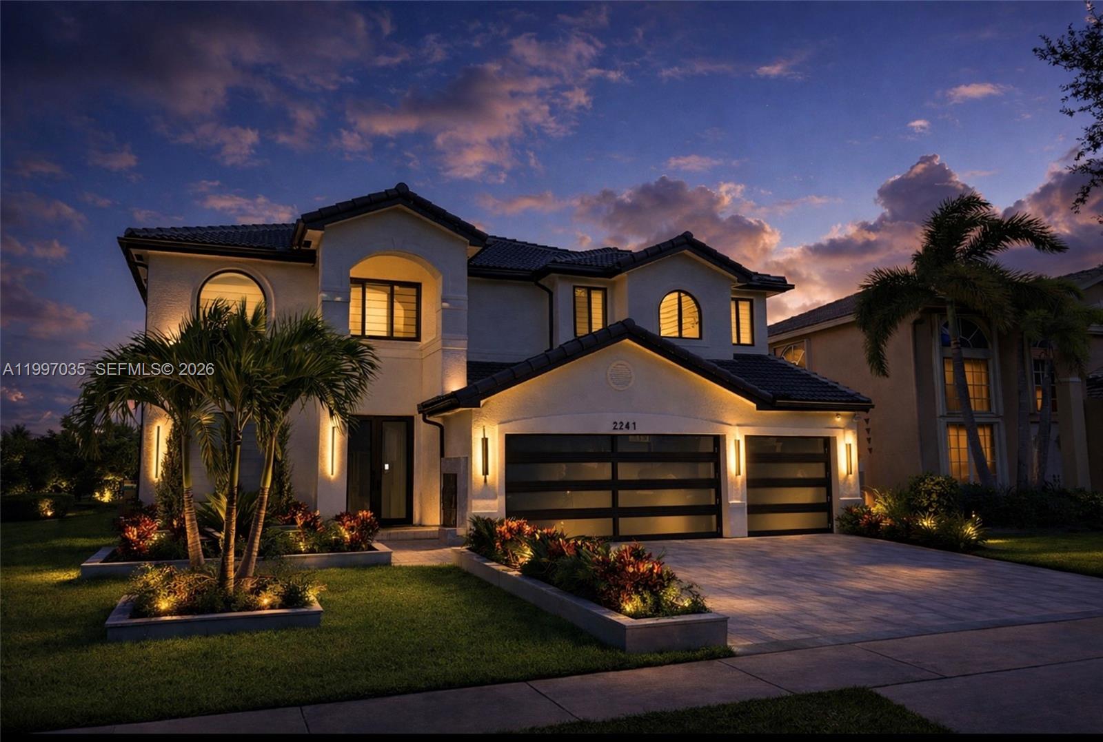 A two-story house with a three-car garage and exterior landscape lighting at dusk — 2241 SW 164th Ave, Miramar FL 33027, MIRAMAR, FL