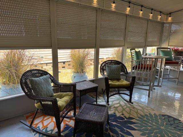A sunroom features wicker rocking chairs, a small table, and a patterned rug — 1001 STARKEY ROAD UNIT 331, LARGO, FL
