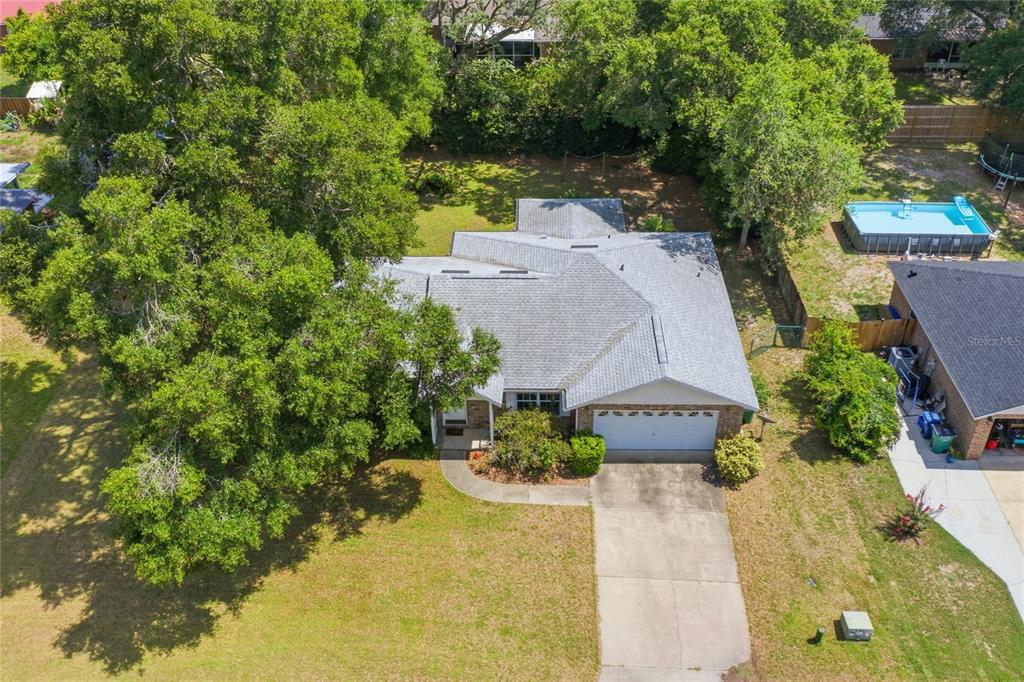 An aerial view shows a single-story house with a gray roof, garage, and backyard pool — 25249 SW 18TH AVENUE, NEWBERRY, FL