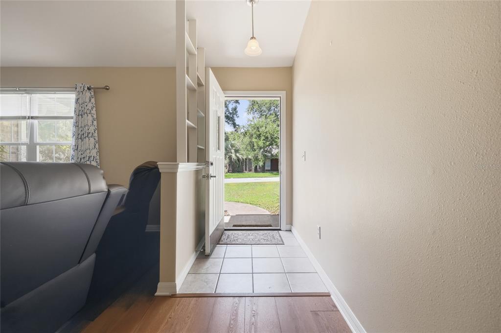 An entryway with tile flooring, a partial shelving wall, and an open door to outdoors — 25249 SW 18TH AVENUE, NEWBERRY, FL