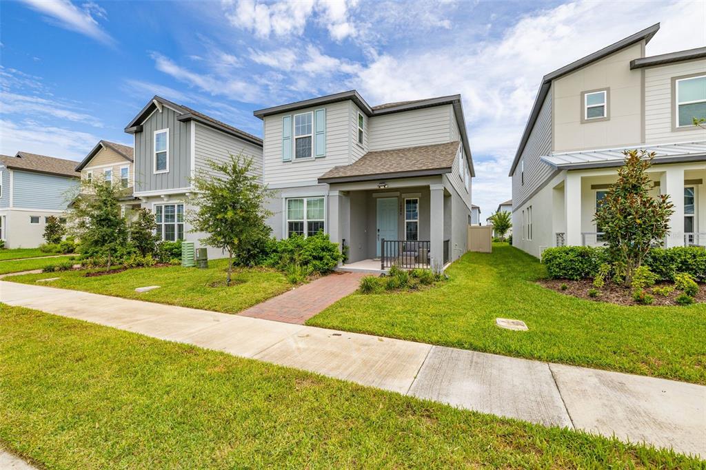 A two-story suburban house with a light blue front door and a brick walkway — 14099 FRASIER STREET, WINTER GARDEN, FL