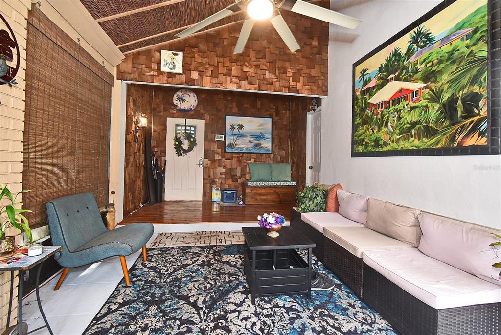 A sunroom features a wood-paneled accent wall, a ceiling fan, and a large area rug — 31 CHIP COURT, KISSIMMEE, FL