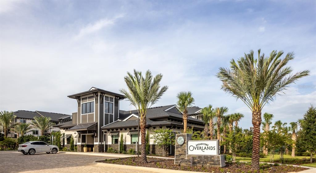 A white car is parked in front of a modern apartment complex with palm trees — 5000 COLLINA TERRACE UNIT B1, CLERMONT, FL