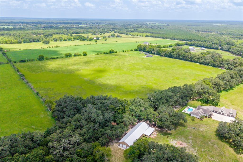 An aerial view shows a large rural property with a house, pool, and barn — 000 SW STATE ROAD 45, NEWBERRY, FL