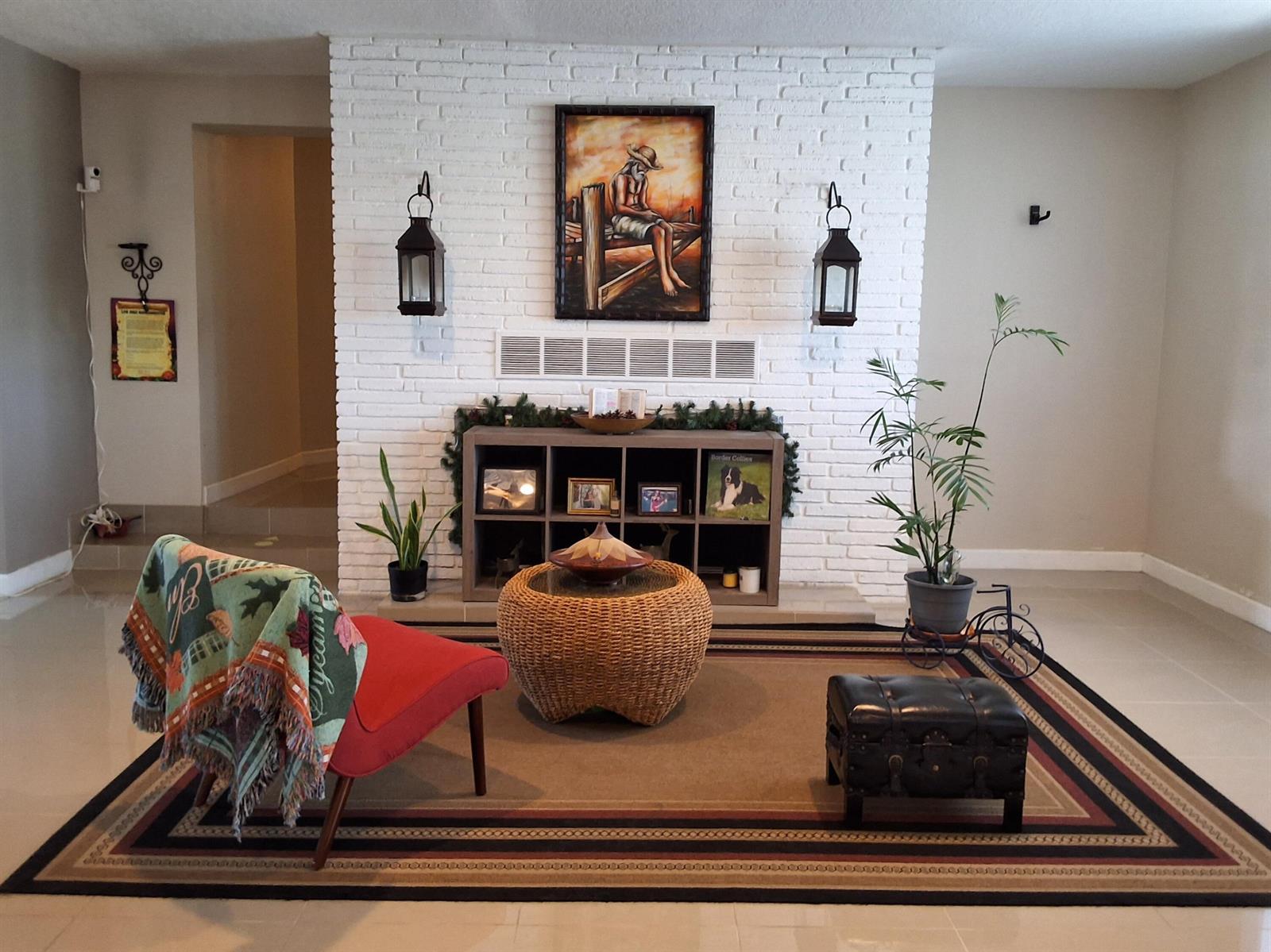 A living room features a white brick fireplace, a red chair, and a woven coffee table — 1221 Bacom Point Road, Pahokee FL 33476, PAHOKEE, FL
