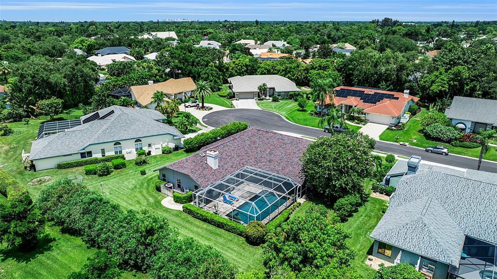 An aerial view shows several suburban houses with swimming pools and lush green lawns — 4528 SPRING FLOWER COURT, SARASOTA, FL
