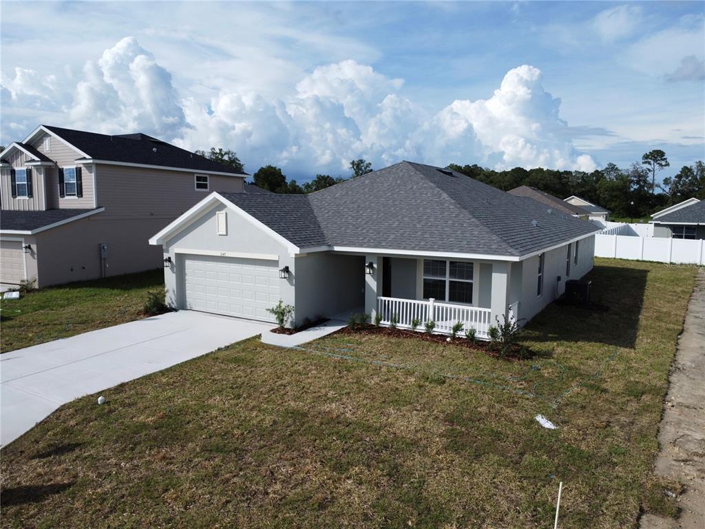A single-story house with a gray roof, light exterior, and a white-railed front porch — 3147 NE 45TH AVENUE, OCALA, FL