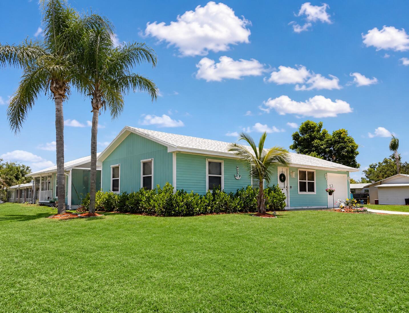 A light blue single-story house with a white roof sits on a green lawn — 4436 SE Beckett Avenue, Stuart FL 34997, STUART, FL