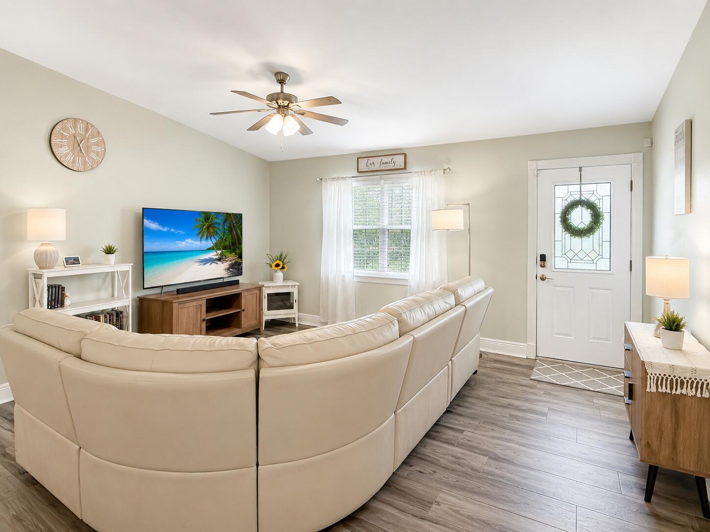 A living room features a large sectional sofa, a television, and light-colored wood flooring — 4436 SE Beckett Avenue, Stuart FL 34997, STUART, FL