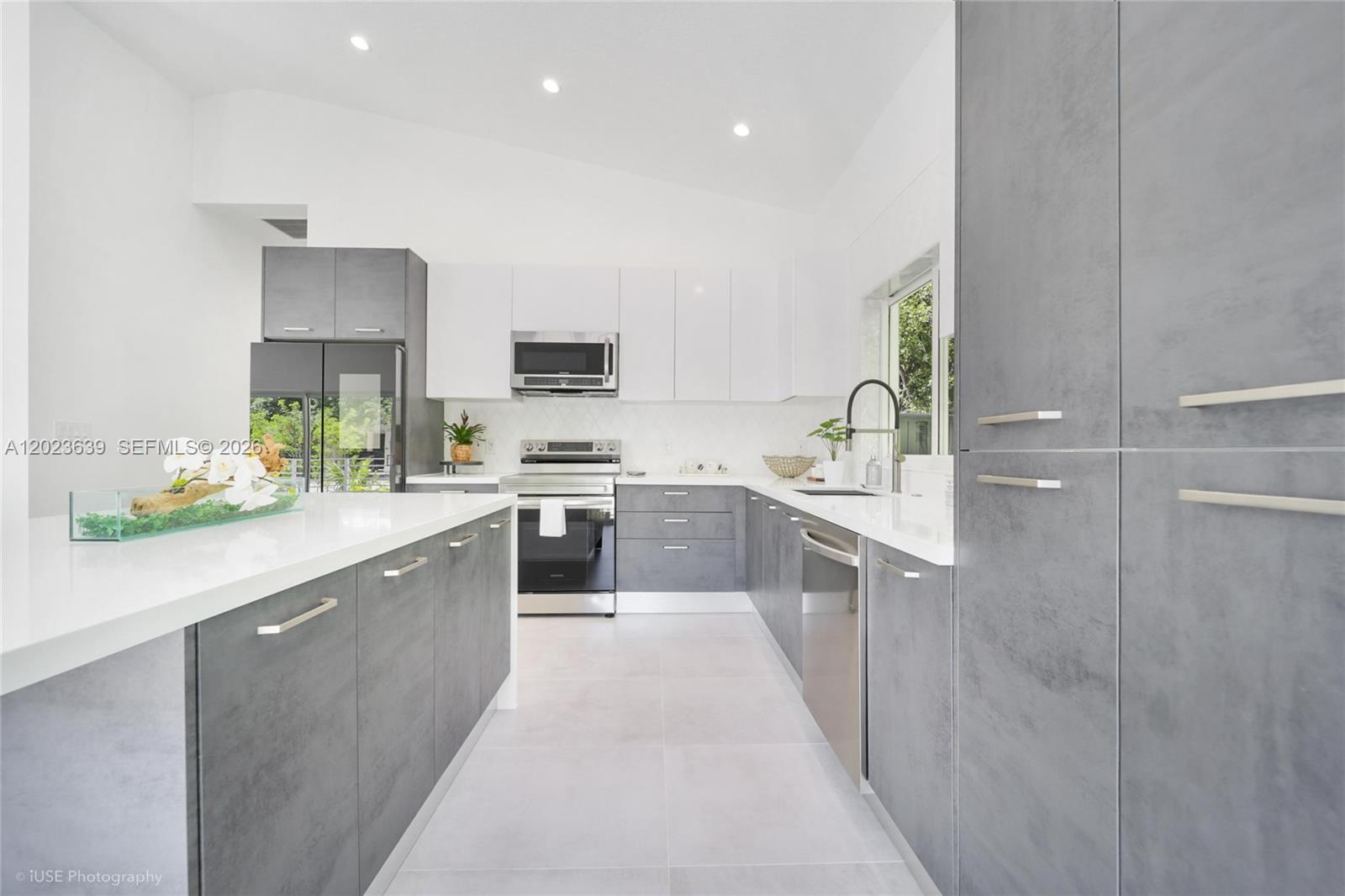 A modern kitchen features gray textured cabinets, white upper cabinets, and white quartz countertops — 5 Bowen Dr, Key Largo FL 33037, KEY LARGO, FL