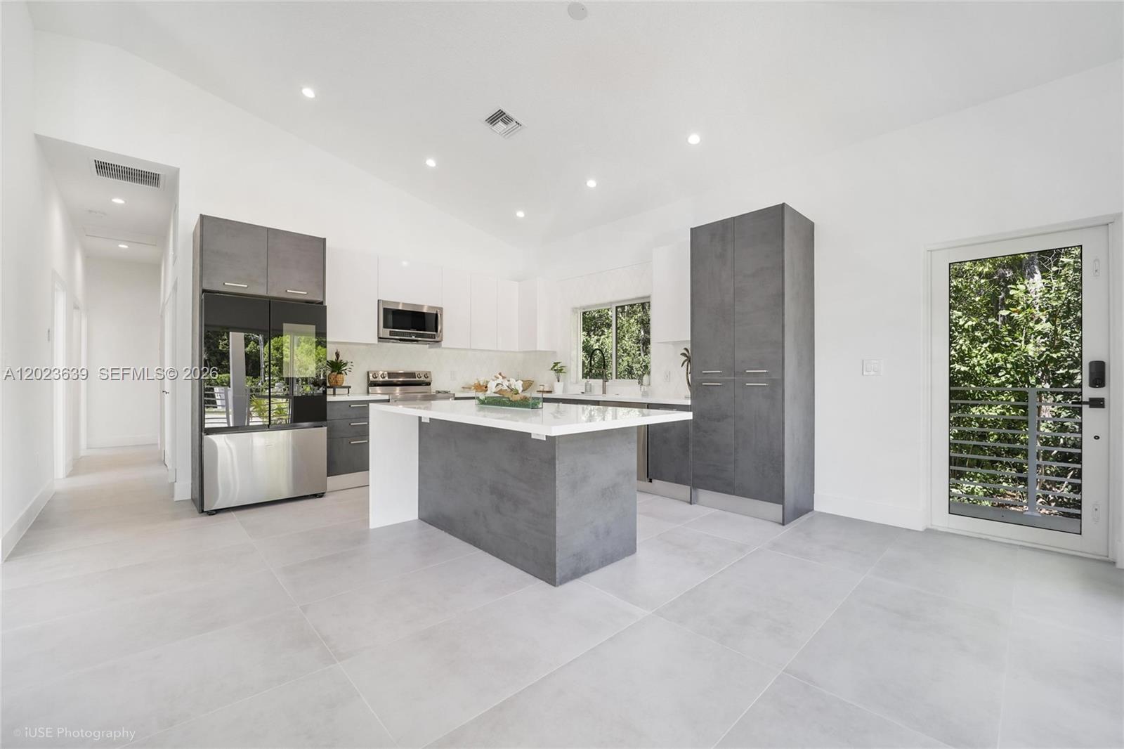 A modern kitchen features a central island, gray cabinetry, white countertops, and light tile flooring — 5 Bowen Dr, Key Largo FL 33037, KEY LARGO, FL