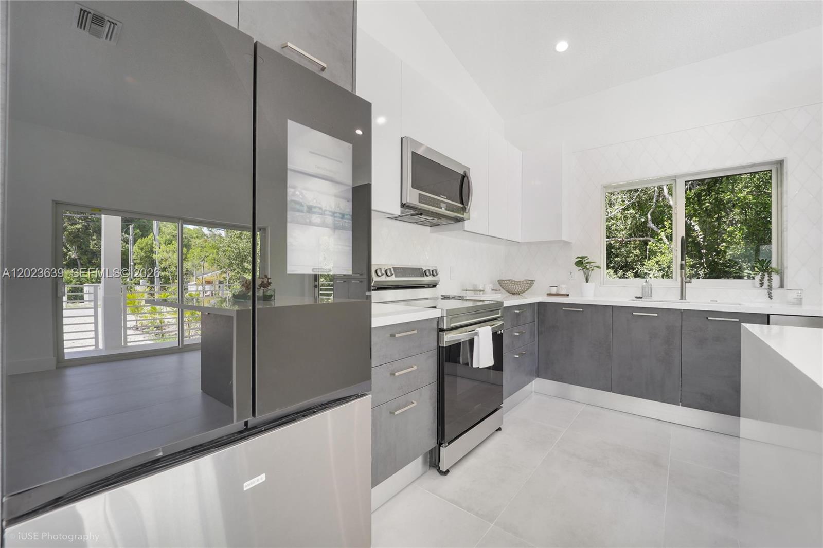 A modern kitchen features gray cabinets, white countertops, stainless steel appliances, and a large window — 5 Bowen Dr, Key Largo FL 33037, KEY LARGO, FL