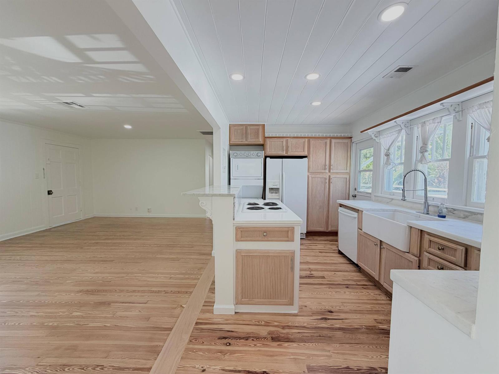 A kitchen with light wood cabinets, white countertops, and a farmhouse sink opens to a room — 1713 Florida Avenue # A2, West Palm Beach FL 33401, WEST PALM BEACH, FL