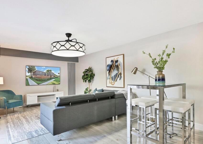 A living room features a gray sectional sofa, a television, and a high-top dining table — 2117 21st Court, Jupiter FL 33477, JUPITER, FL